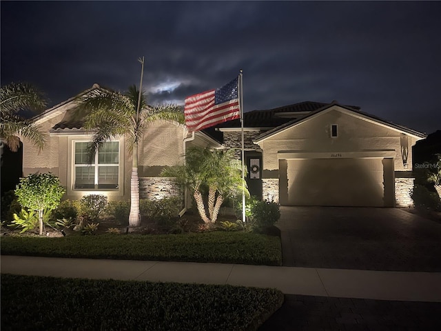 20296 Bandera Pl, Venice, FL 34293 - view of front of house featuring a garage, concrete driveway, and stucco siding