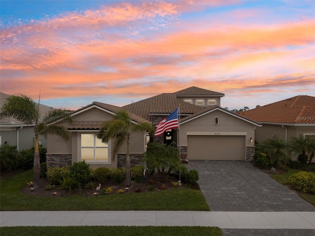 20296 Bandera Pl, Venice, FL 34293 - view of front facade featuring stone siding, a garage, stucco siding, and decorative driveway