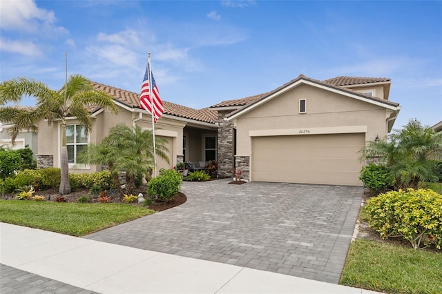20296 Bandera Pl, Venice, FL 34293 - view of front of property featuring stone siding, stucco siding, an attached garage, decorative driveway, and a tile roof