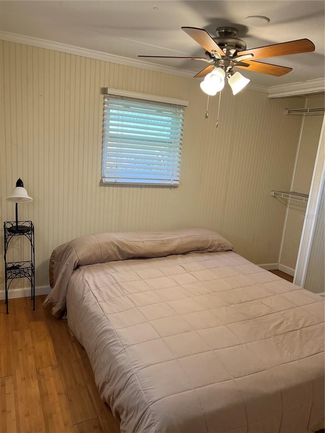 bedroom featuring crown molding, ceiling fan, and hardwood / wood-style flooring