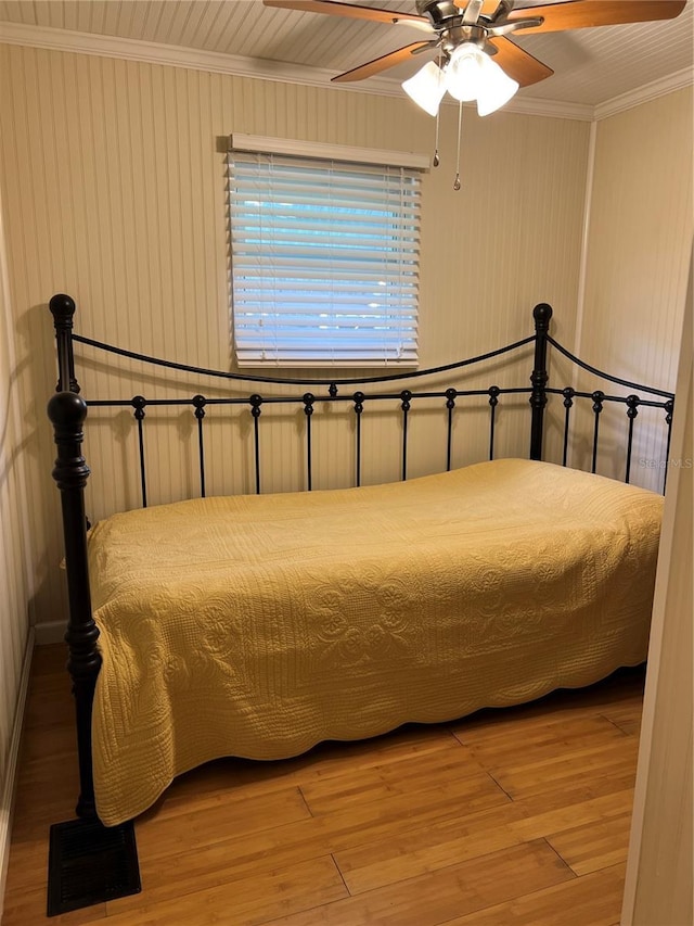 bedroom featuring ornamental molding, wood-type flooring, and ceiling fan