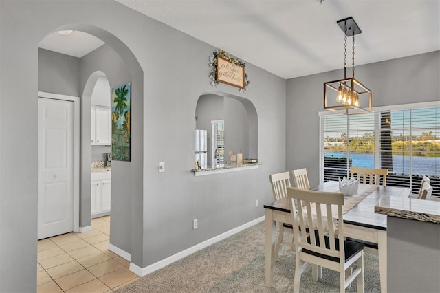 dining space with light tile patterned floors and a chandelier