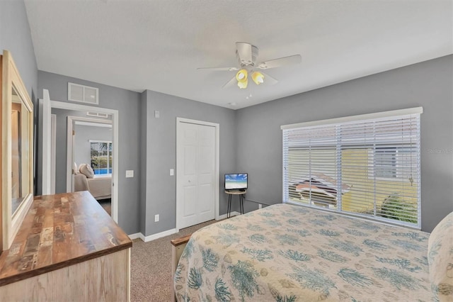 carpeted bedroom featuring ceiling fan and a closet