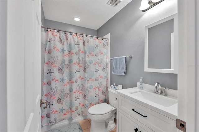 bathroom featuring tile patterned flooring, vanity, toilet, and walk in shower