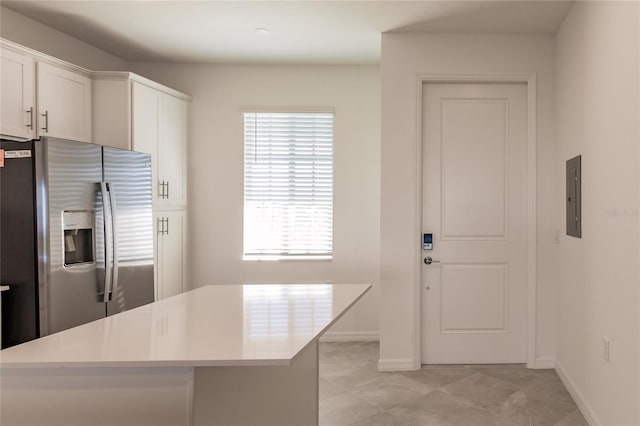 kitchen with electric panel, white cabinets, and stainless steel fridge