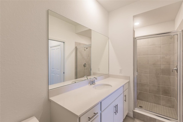 bathroom with a shower with door and vanity