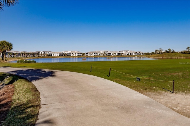 view of community with a lawn and a water view