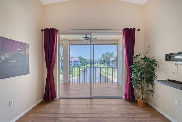 interior space with ceiling fan and a water view