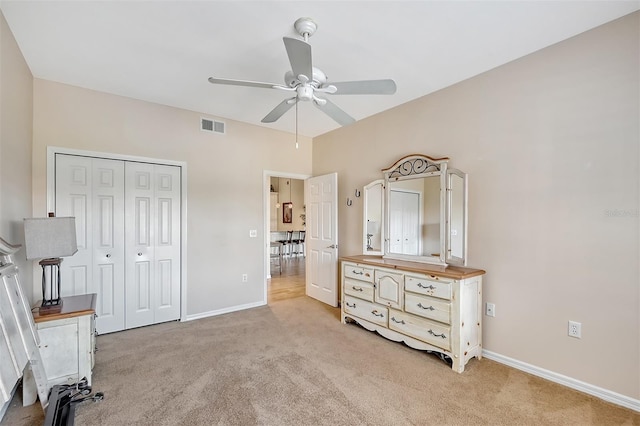 carpeted bedroom featuring ceiling fan and a closet