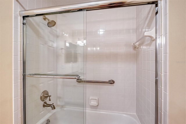 bathroom with combined bath / shower with glass door