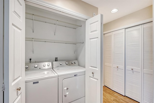 washroom with washer and dryer and light wood-type flooring