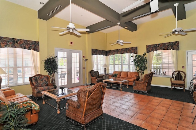 tiled living room with ceiling fan, french doors, beamed ceiling, and a healthy amount of sunlight