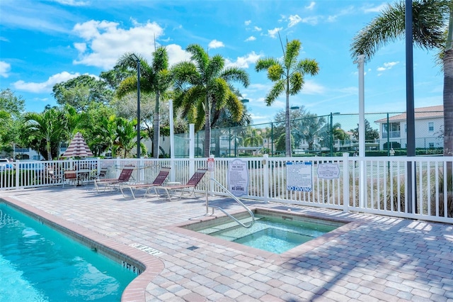 view of swimming pool featuring a patio area and a hot tub