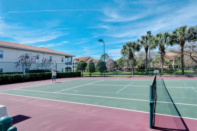 view of tennis court featuring basketball hoop