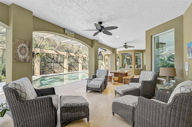 view of patio featuring ceiling fan and glass enclosure