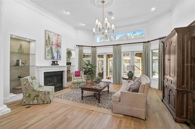 living room with ornamental molding, light hardwood / wood-style flooring, and a wealth of natural light