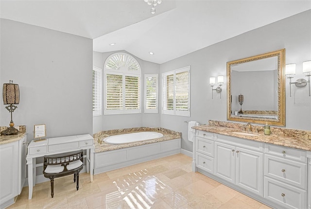 bathroom with vanity, lofted ceiling, and a bathtub