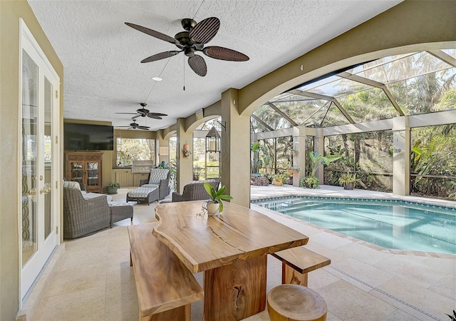 view of swimming pool featuring outdoor lounge area, ceiling fan, glass enclosure, a patio area, and french doors