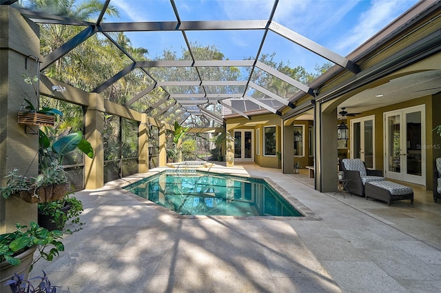 view of pool with french doors, a lanai, an in ground hot tub, ceiling fan, and a patio