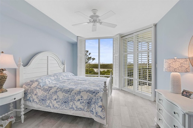 bedroom with access to exterior, light hardwood / wood-style floors, floor to ceiling windows, and ceiling fan