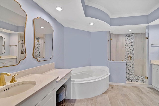 bathroom with plus walk in shower, wood-type flooring, and vanity