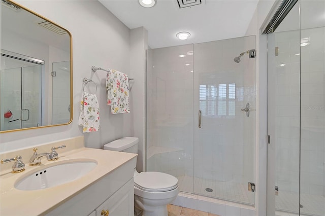 bathroom featuring tile patterned flooring, vanity, toilet, and an enclosed shower