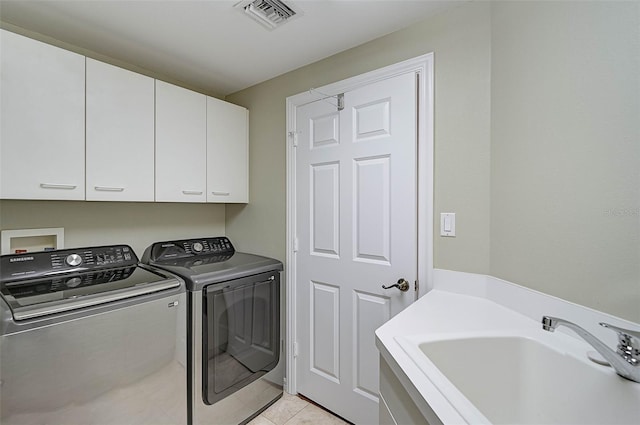 washroom featuring cabinets, separate washer and dryer, sink, and light tile patterned floors