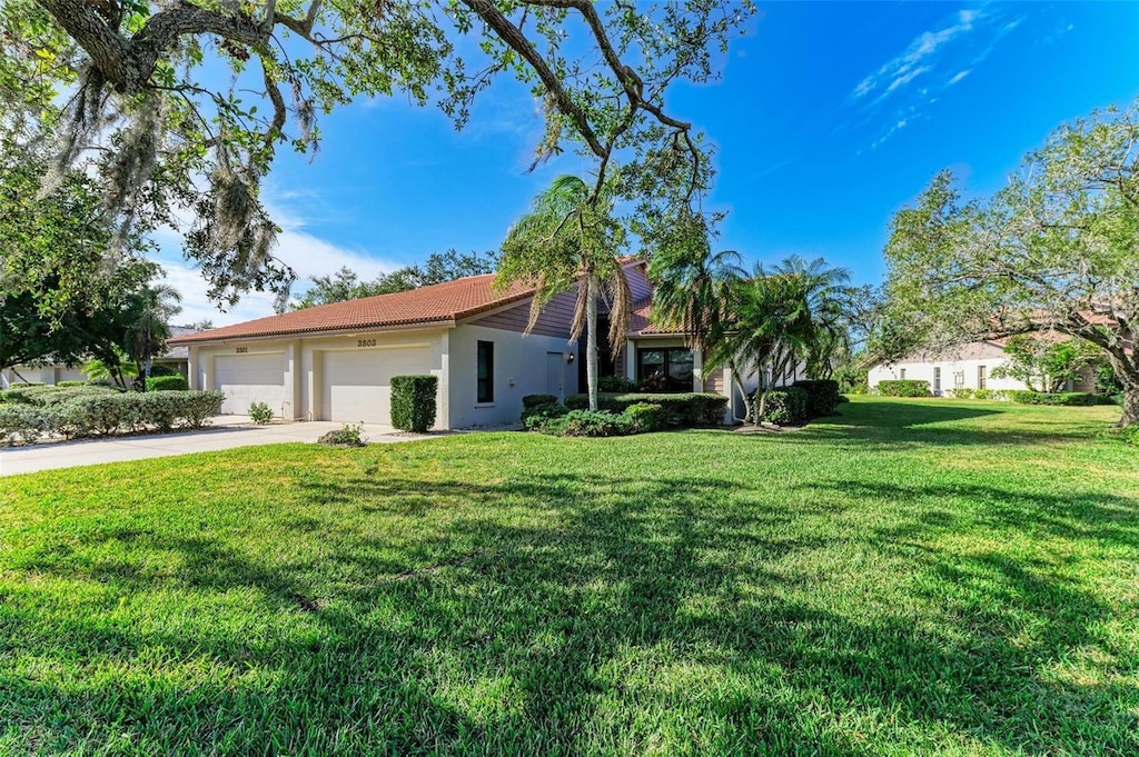 ranch-style home featuring a front lawn and a garage