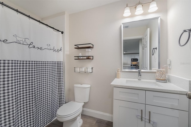 bathroom featuring toilet, vanity, and wood-type flooring