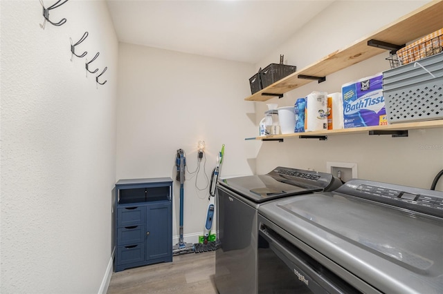 clothes washing area featuring light hardwood / wood-style floors and independent washer and dryer