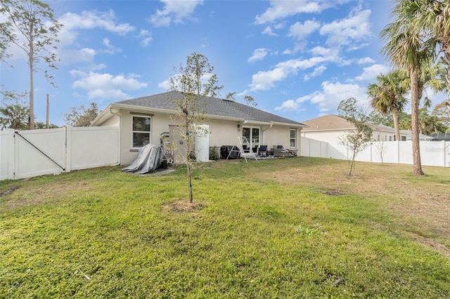 rear view of house featuring a lawn