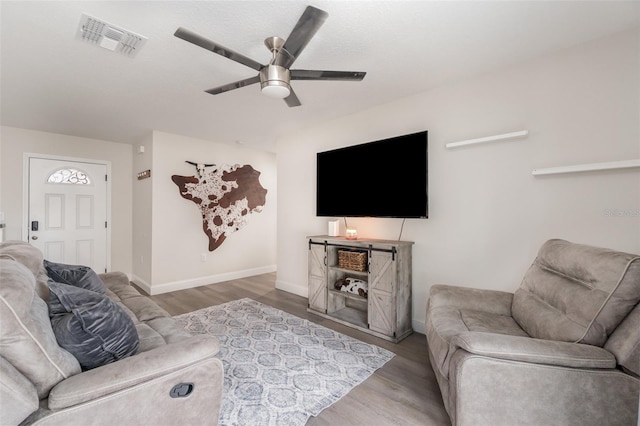 living room featuring ceiling fan and wood-type flooring