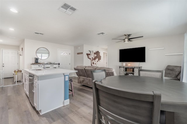 kitchen featuring sink, white cabinetry, a center island with sink, and light hardwood / wood-style flooring