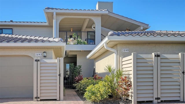 property entrance featuring a balcony and a garage