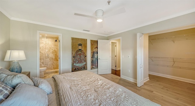 bedroom featuring ensuite bathroom, light hardwood / wood-style flooring, ceiling fan, ornamental molding, and a closet