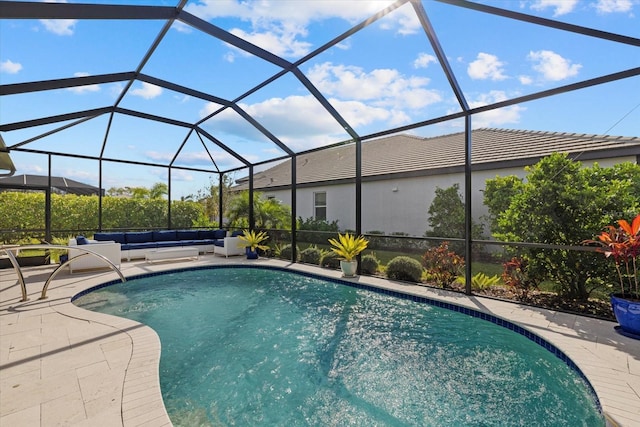 view of pool with glass enclosure and a patio area