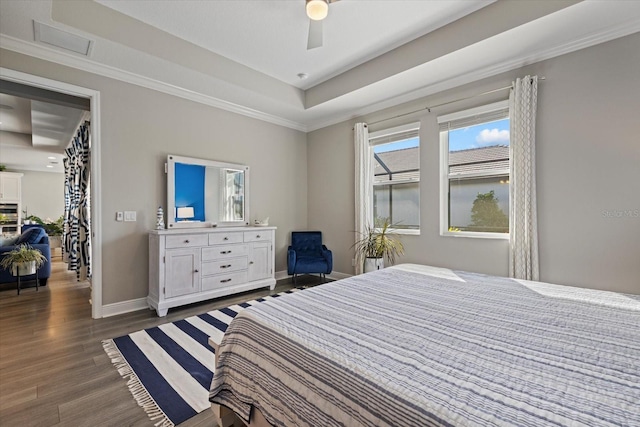 bedroom featuring dark hardwood / wood-style flooring, a raised ceiling, ceiling fan, and ornamental molding