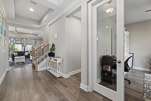 foyer entrance with wood-type flooring, a tray ceiling, and ceiling fan