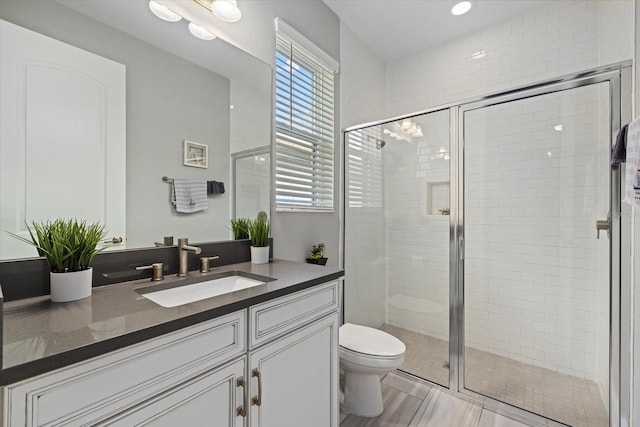 bathroom featuring tile patterned floors, vanity, toilet, and an enclosed shower