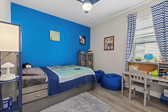 bedroom featuring multiple windows, light hardwood / wood-style floors, and ceiling fan