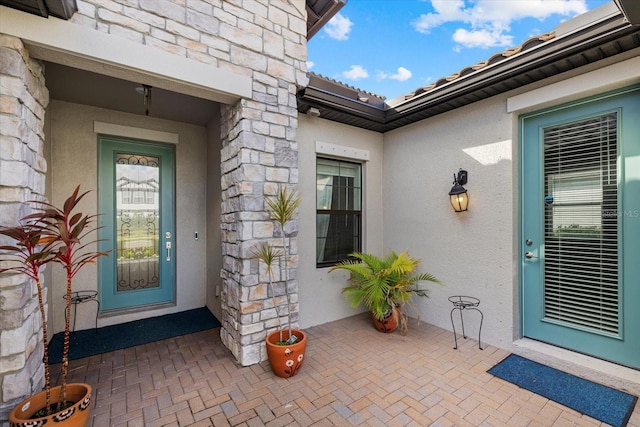 entrance to property with stone siding and stucco siding