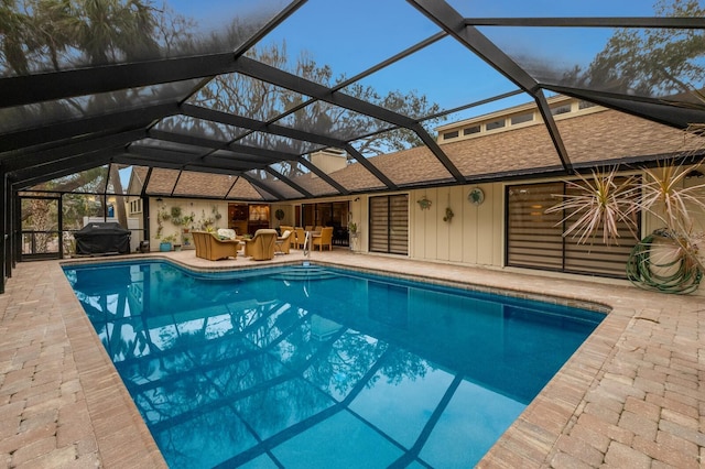 view of pool featuring grilling area, glass enclosure, a patio area, and outdoor lounge area