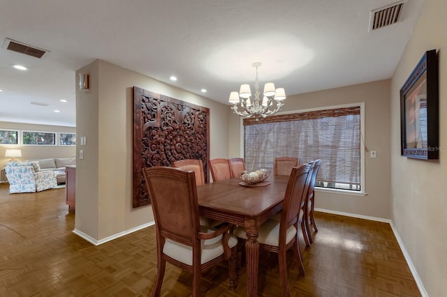 dining room featuring dark parquet flooring and a notable chandelier