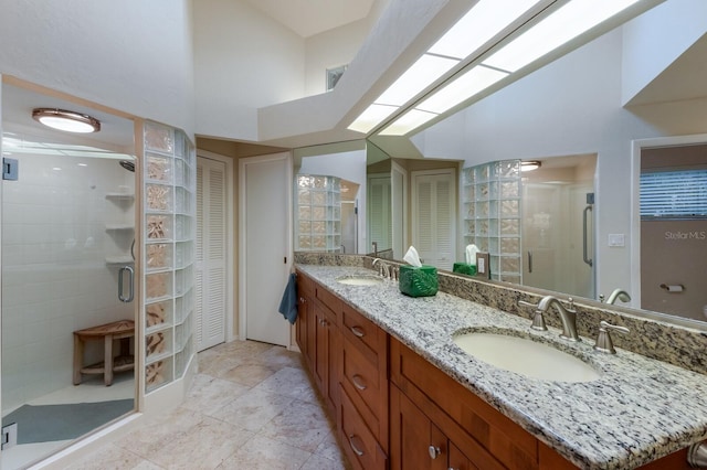 bathroom featuring a shower with shower door, vanity, and a towering ceiling