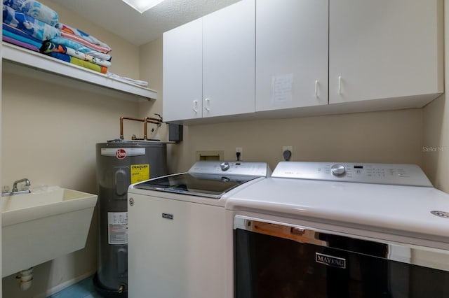 laundry room with electric water heater, sink, washing machine and clothes dryer, a textured ceiling, and cabinets