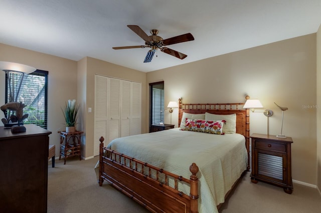 carpeted bedroom with ceiling fan and a closet