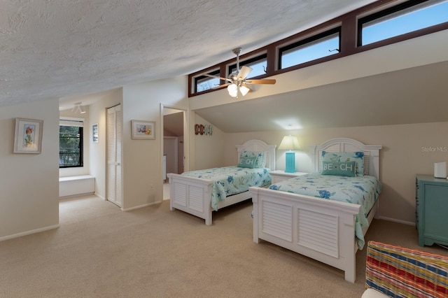 bedroom with ceiling fan, light carpet, a textured ceiling, and lofted ceiling