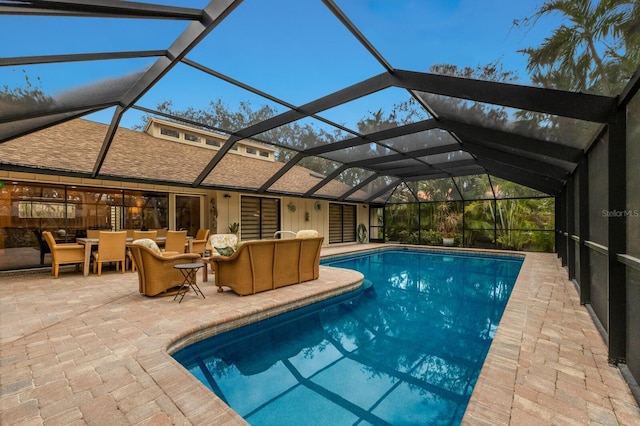 view of swimming pool featuring a patio, outdoor lounge area, and glass enclosure