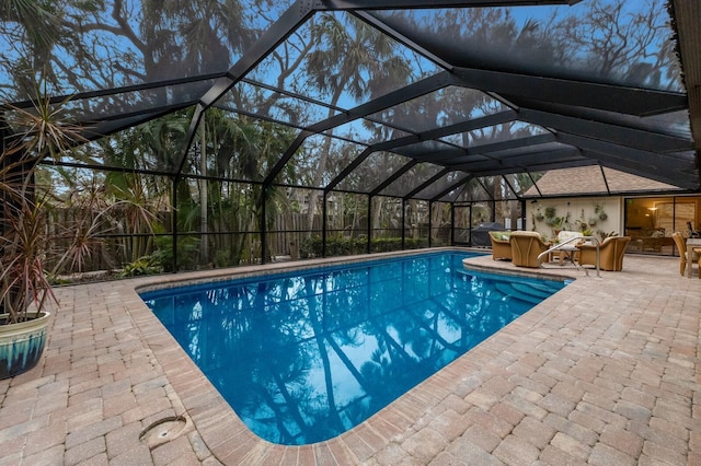 view of pool featuring an outdoor hangout area, glass enclosure, and a patio area