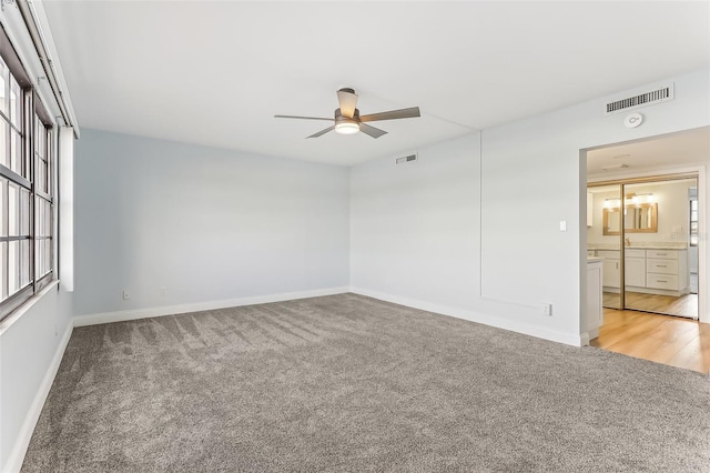 unfurnished room with ceiling fan, plenty of natural light, and light carpet